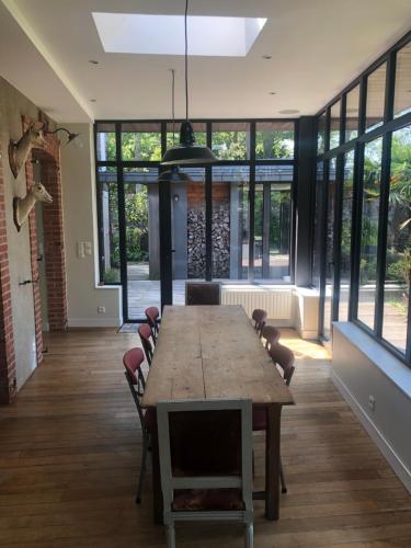 une grande salle à manger avec une longue table et des chaises dans l'établissement Mon Plaisir de Carteret, à Barneville-Carteret