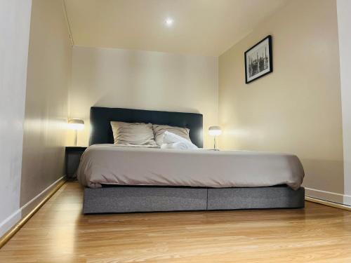 a bedroom with a large bed with two lamps at Suite Adamas in Lyon