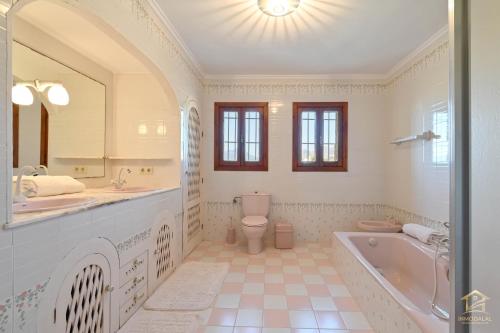 a bathroom with a tub and a toilet and a sink at Villa Katerina in Benissa