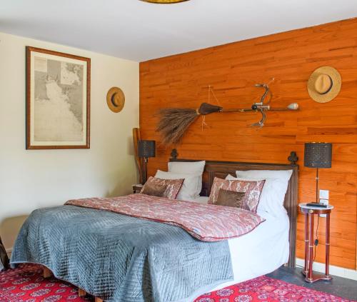 a bedroom with a bed with a wooden wall at Les Pierres Bleues in Saint-Coulitz