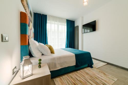 a bedroom with a large bed with blue curtains at Alezzi Luxury Apartments & Spa Center in Mamaia Sat/Năvodari