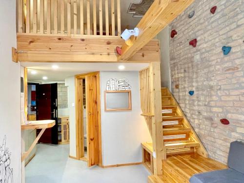 a room with a staircase and a brick wall at Lavender Circus Hand Drawn Apartments in Budapest