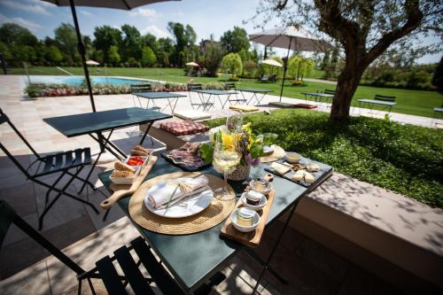 - une table avec des assiettes de nourriture sur une terrasse dans l'établissement COBUE "Wine resort & Spa", à Pozzolengo