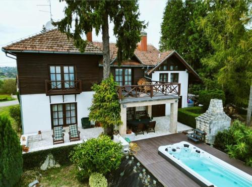 una casa con piscina frente a ella en Villa Wolf Castle - vanjski grijani bazen en Lopatinec