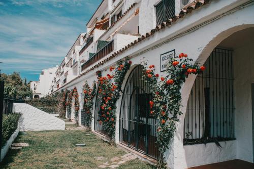 a building with red flowers on the side of it at Playa Las Fuentes Bello LUXURY Apartament Pp2 PET in Alcossebre