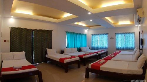 a living room with couches and chairs and windows at LaVeranda Beach Resort in Dauis