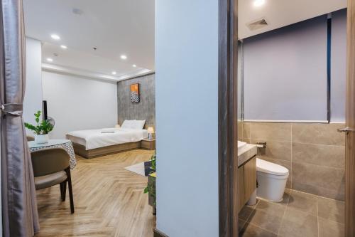 a bathroom with a toilet and a bed in a room at Westlake Emerald Suites in Hanoi