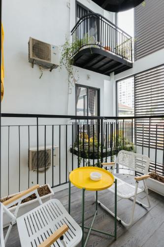 a patio with a yellow table and chairs on a balcony at Westlake Emerald Suites in Hanoi