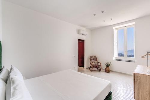 a white bedroom with a bed and a window at Villa Giulia Boutique Views Pool and Guest Services by Feeling Italy in Sorrento