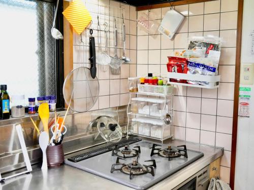 a kitchen with a stove top oven in a kitchen at Soma Guesthouse mawari in Soma