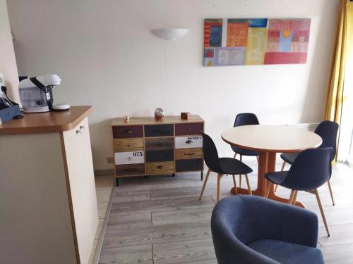 Studio au coeur de Quiberon في كويبيرون: غرفة مع طاولة وكراسي ومكتب