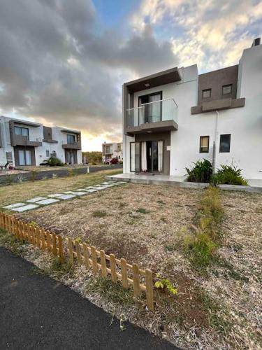 a large white building with a fence in front of it at North Mauritius New-built 2-bedroom Villa with shared pool in Grand Gaube