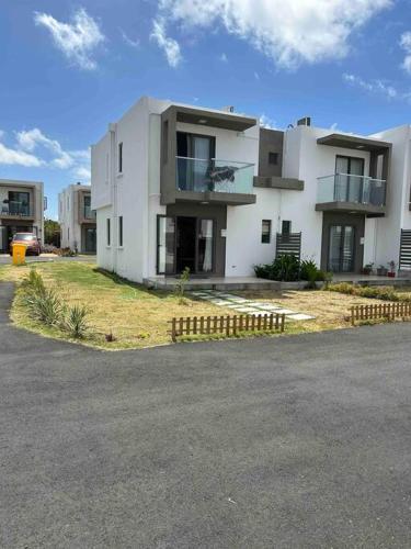 a large white building on the side of a street at North Mauritius New-built 2-bedroom Villa with shared pool in Grand Gaube