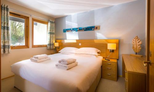 a bedroom with a large white bed with towels on it at Keswick Bridge Lodge Resort in Keswick