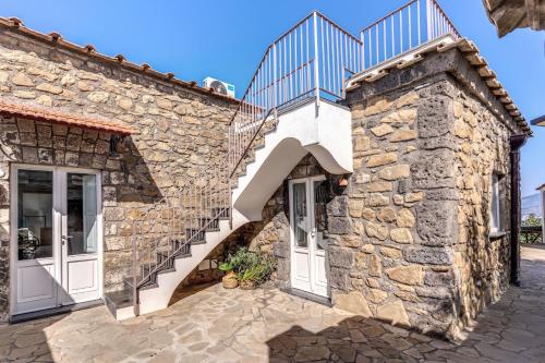 an external view of a stone house with stairs at Villa Giulia Boutique Views Pool and Guest Services by Feeling Italy in Sorrento
