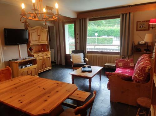 a living room with a wooden table and a couch at Appartement Morzine 1000 - 6 pers in Morzine