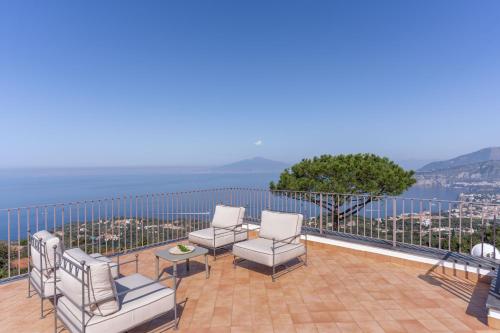 a balcony with chairs and a view of the water at Villa Giulia Boutique Views Pool and Guest Services by Feeling Italy in Sorrento