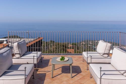 a patio with chairs and a table and the ocean at Villa Giulia Boutique Views Pool and Guest Services by Feeling Italy in Sorrento