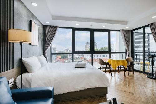 a bedroom with a large bed and a table and chairs at Westlake Emerald Suites in Hanoi