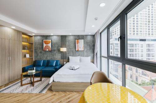 pokój hotelowy z łóżkiem i niebieską kanapą w obiekcie Westlake Emerald Suites w mieście Hanoi