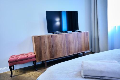 a tv sitting on a dresser in a bedroom at COZY apartment in the City Center in Vilnius