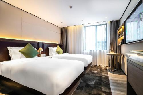 Habitación de hotel con 2 camas y TV en 宜尚Plus酒店广州北京路步行街店, en Guangzhou