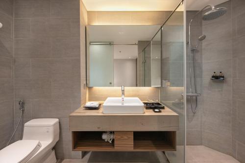 ein Bad mit einem Waschbecken und einer Dusche in der Unterkunft Avora Hotel in Đà Nẵng