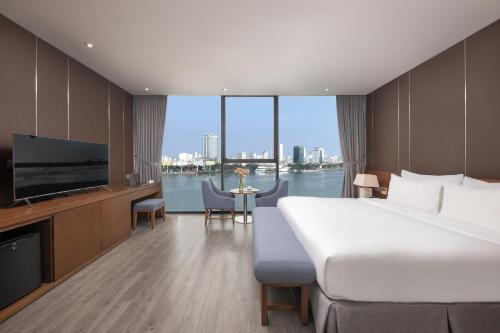 a hotel room with a large bed and a television at Avora Hotel in Da Nang