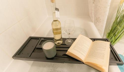 a tray with a book and a bottle of wine and a glass at CBlue "Turmresidenz", zentral, familienfreundlich, Schatzsuche in Wismar