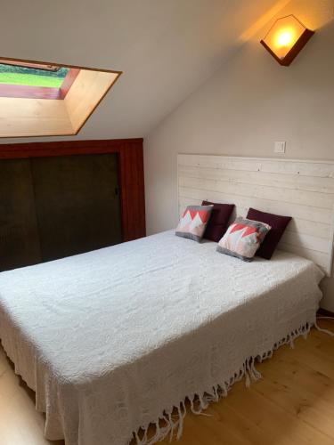 - une chambre avec un grand lit blanc et une lucarne dans l'établissement le gite des vignes Studio tout confort 1 chambre dans le vignoble Franche Comte Arbois, à Arbois