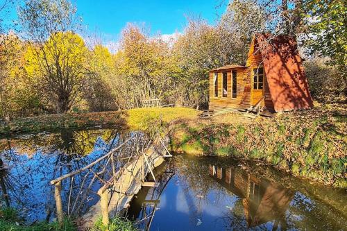 a small cabin in the middle of a river with a bridge at Fisherman's Cabin (Friendship Land) in Şelari