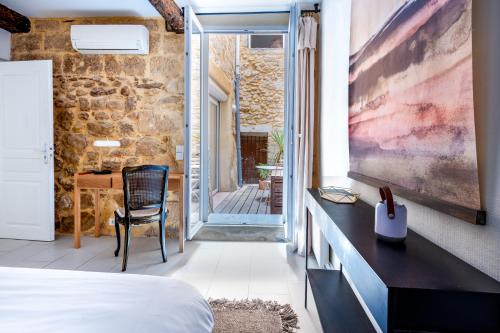 une chambre avec un lit et une table avec une chaise dans l'établissement Les Voûtes Centre historique de Montpellier, à Montpellier
