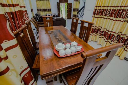 una mesa de madera con una bandeja de tazas. en King Coco Villa Hikkaduwa, en Galle