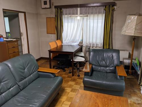 a living room with a couch and a table and chairs at 小江戸川越ハウス in Kawagoe