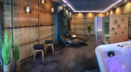 a bathroom with a tub and a table and chairs at La folie 20 Spa in Hon-Hergies
