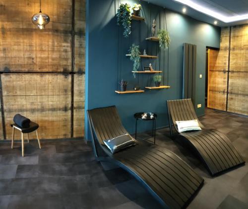 a waiting room with two chairs and a blue wall at La folie 20 Spa in Hon-Hergies