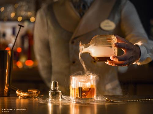 a person pouring a drink into a glass at Disneyland® Hotel in Chessy