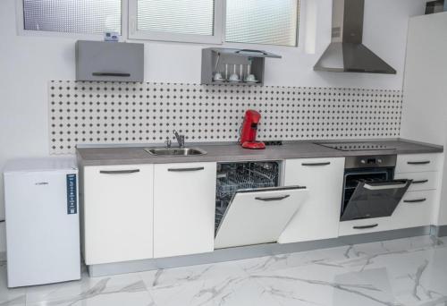 una cocina con armarios blancos y fregadero en BB Residence en Arad