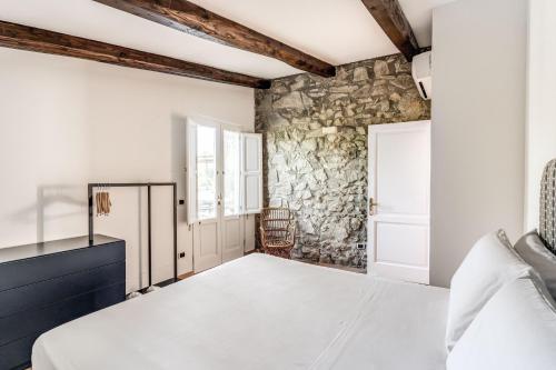 a bedroom with a bed and a stone wall at Villa Giulia Boutique Views Pool and Guest Services by Feeling Italy in Sorrento