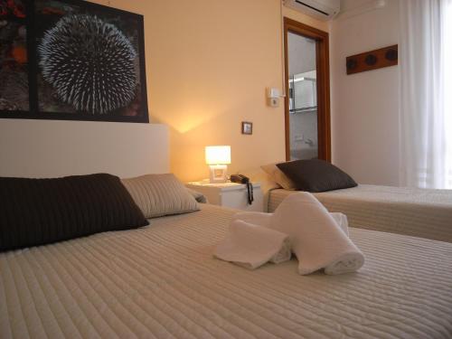 1 dormitorio con 2 camas y toallas. en Hotel Moreri, en Grado
