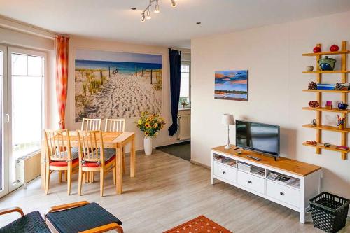 ein Wohnzimmer mit einem Esstisch und einem TV in der Unterkunft Ferienappartement Fraenzi mit herrlichem Seeblick in Sassnitz
