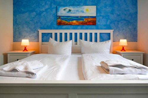 sypialnia z dużym białym łóżkiem z 2 lampami w obiekcie Ferienappartement Fraenzi mit herr w mieście Sassnitz