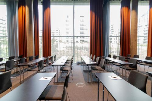 a row of tables and chairs in a room with windows at Quality Hotel Hasle Linie in Oslo
