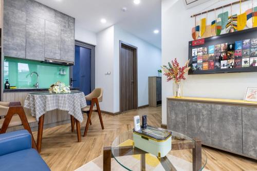 a living room with a table and a kitchen at Westlake Emerald Suites in Hanoi