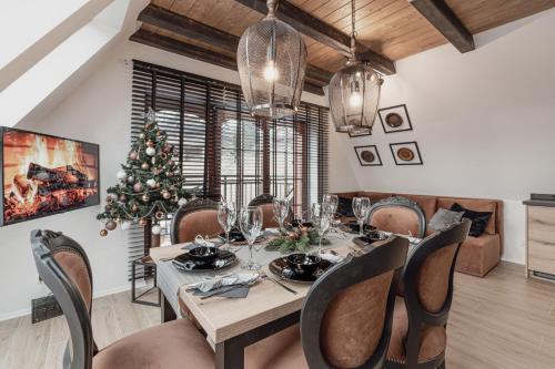 a dining room with a table and a christmas tree at Góralska Prowincja in Kościelisko