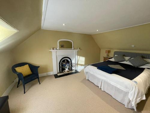 a bedroom with a large bed and a fireplace at The Fiddichside Inn in Aberlour