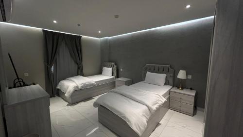 a bedroom with two beds in a room at لاقونا للشقق المخدومة in Al Ahsa