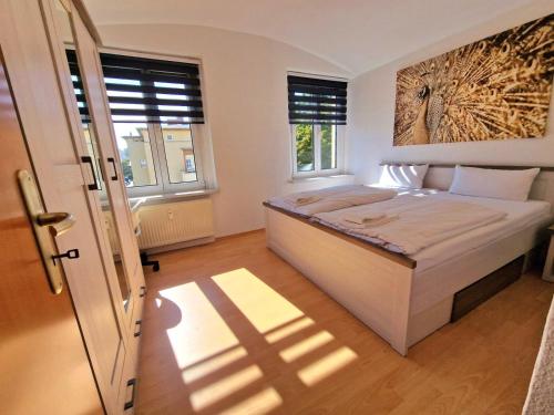1 Schlafzimmer mit einem großen weißen Bett und 2 Fenstern in der Unterkunft Ferienwohnung Chemnitz Zentrum mit Stellplatz Frühstück möglich in Chemnitz
