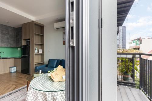 a kitchen and living room with a table and a balcony at Westlake Emerald Suites in Hanoi