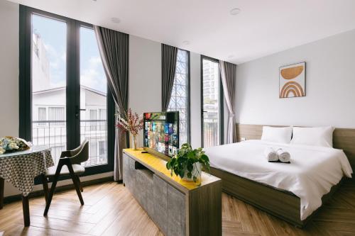 una camera con letto e scrivania con TV di Westlake Emerald Suites a Hanoi